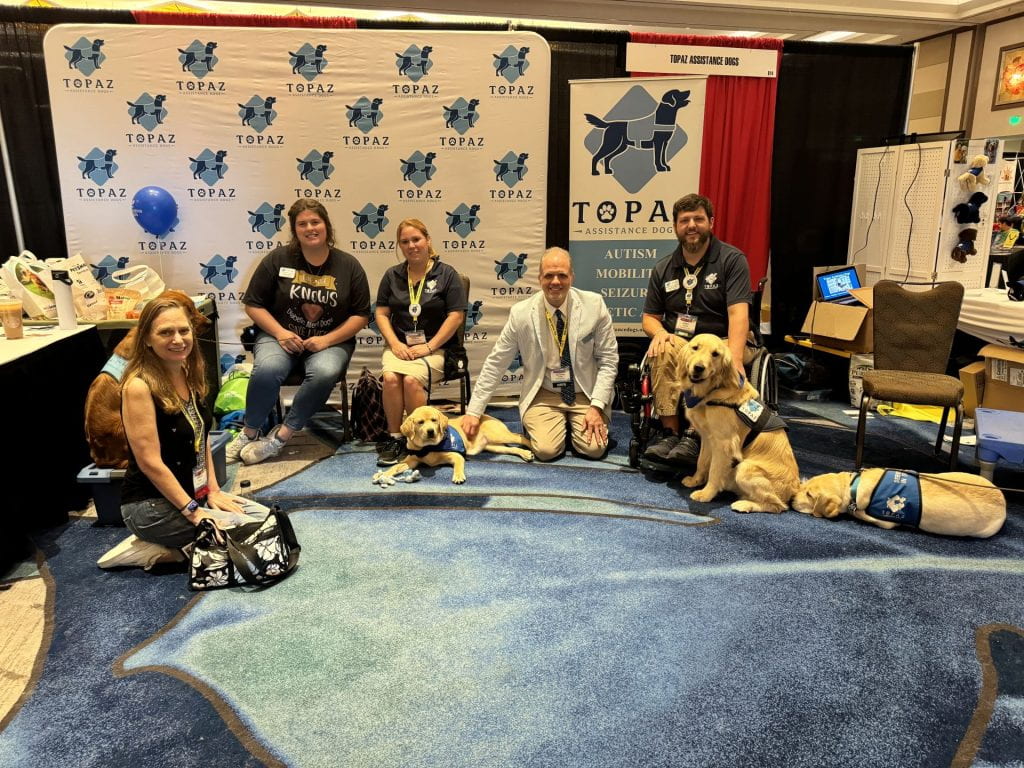 Topaz Dog Training booth with two men, three women and three dogs