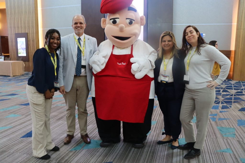 three women, one man and one large costumed figure that is the chef logo of Family Cafe